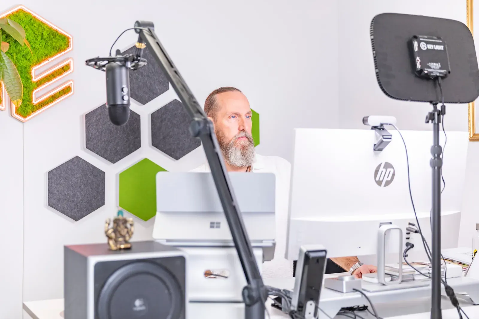 Arbeitsplatz von memedia mit Mikrofon und Monitoren, Benno Schmidtler im Hintergrund