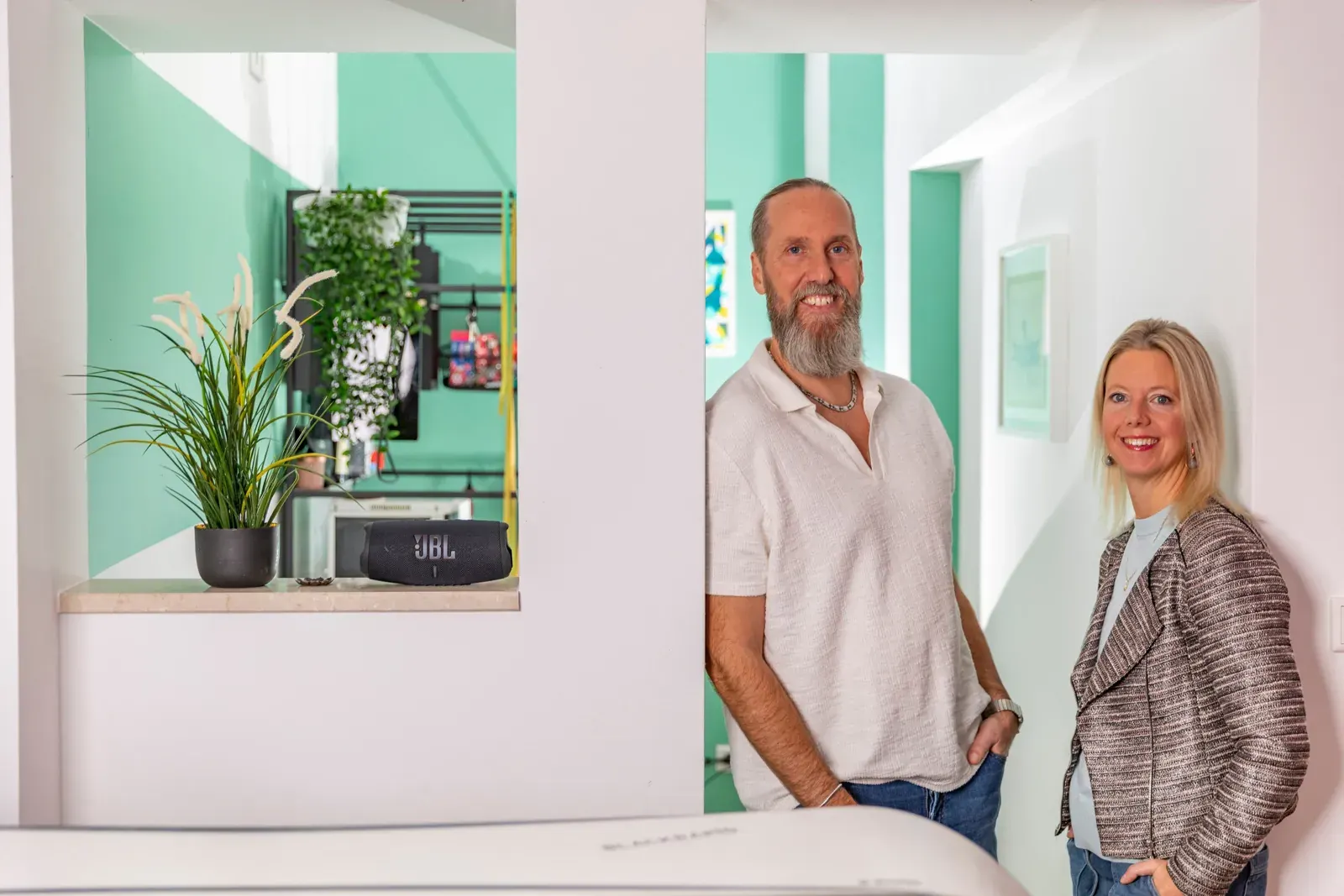 Benno Schmidtler und Melanie Hoffmann im Flur vor einer mintfarbenen Wand