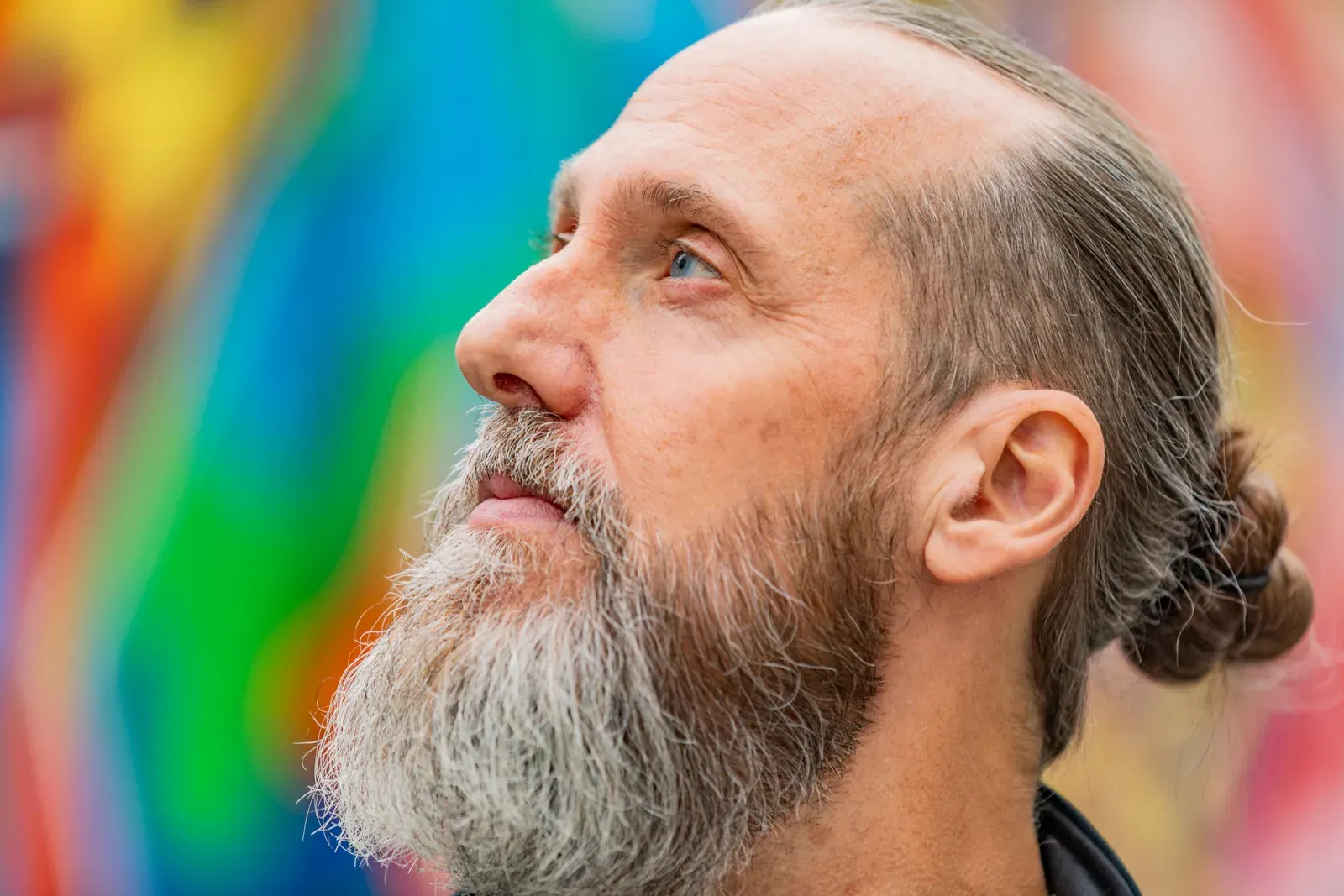 Benno Schmidtler im Profil vor einer bunten Graffiti-Wand